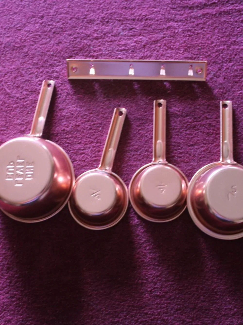 4-piece copper colored metal  measuring cups, complete with a matching hanger